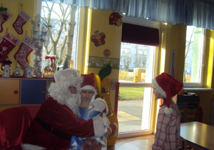 Mikołaj wręcza prezent Nadii i Oli